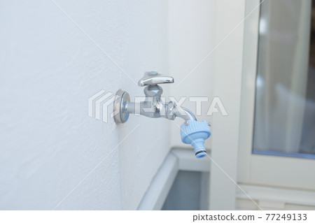 A faucet attached to the balcony of a house A faucet attached to the balcony of a house 77249133