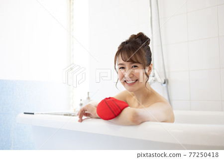 A young woman taking a bath A young woman taking a bath 77250418