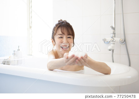 A young woman taking a bath A young woman taking a bath 77250478