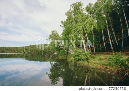 the concept of weather observation, meteorology. wind and small waves. Landscape by the river, trees and sandy beach the concept of weather observation, meteorology. wind and small waves. Landscape by the river, trees and sandy beach 77250758