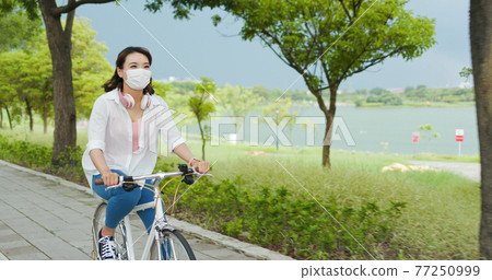 Asian female ride bicycle 77250999