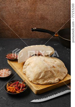 Cut lamb fat tail on kitchen table Cut lamb fat tail on kitchen table 77253200