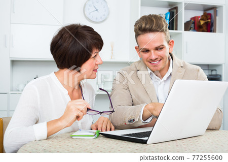 Mature mom and son consider software on laptop Mature mom and son consider software on laptop 77255600