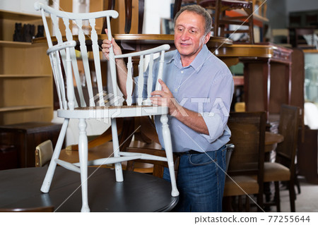 adult man is buying antique furniture in store adult man is buying antique furniture in store 77255644