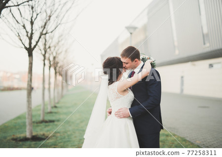 Gorgeous wedding couple walking in the old city of Lviv 77258311