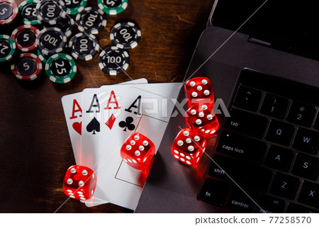 Online gambling concept. Red playing dice, chips and cards on a wooden desk. Top view Online gambling concept. Red playing dice, chips and cards on a wooden desk. Top view 77258570