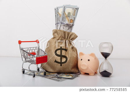 Dollar money bag, ohurglass and a shopping cart on white background 77258585