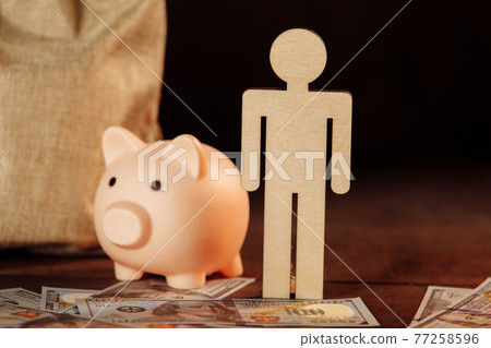 Bag of money, piggy bank and figure of man close-up.The concept of investment and savings 77258596