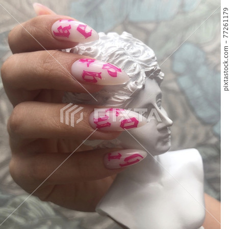 Stylish trendy female white manicure with design.Hands of a woman with white manicure on nails Stylish trendy female white manicure with design.Hands of a woman with white manicure on nails 77261179