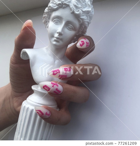 Stylish trendy female white manicure with design.Hands of a woman with white manicure on nails 77261209