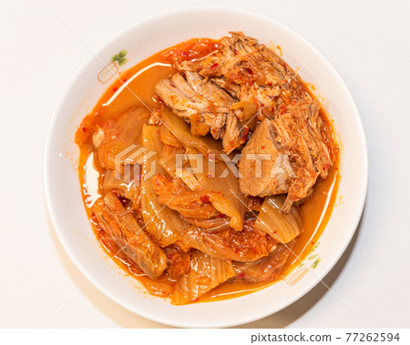 Photographing a Korean dish of pork kimchi stew on a plate. 77262594