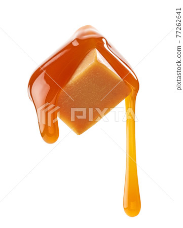 caramel sauce flowing on flying caramel candy 77262641