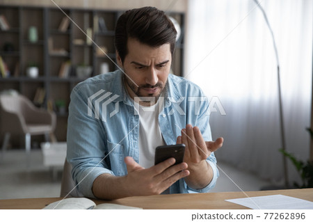 Close up unhappy man looking at phone screen, bad news 77262896