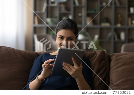 Close up happy Indian woman using tablet, having fun Close up happy Indian woman using tablet, having fun 77263031