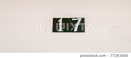 Decorative ceramic house number 17 tile on the wall, characteristic decorative element, number 77263806