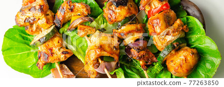 Grilled skewers with chicken, zucchini, mushrooms, peppers and onions served on iceberg lettuce Grilled skewers with chicken, zucchini, mushrooms, peppers and onions served on iceberg lettuce 77263850