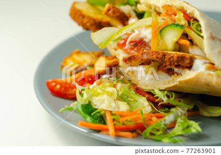 Mediterranean style pitta prepared with spicy chicken, cucumber, tomato, salad and mayo sauce Mediterranean style pitta prepared with spicy chicken, cucumber, tomato, salad and mayo sauce 77263901