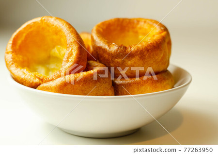 Traditional English Yorkshire pudding, wonderfully crisp and golden baked for a traditional recipe, accompaniment for the perfect Sunday roast 77263950