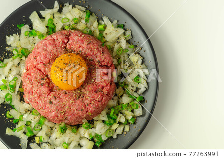 Beef steak tartare with raw egg yolk and onion with chive Beef steak tartare with raw egg yolk and onion with chive 77263991