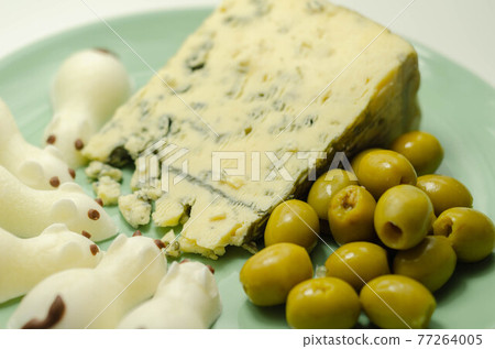 Full fat soft blue veined cheese with olives and snacks in the shape of mice Full fat soft blue veined cheese with olives and snacks in the shape of mice 77264005