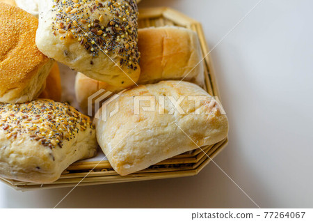 Various types of bread served on a wicker tray, delicious and fresh rolls Various types of bread served on a wicker tray, delicious and fresh rolls 77264067