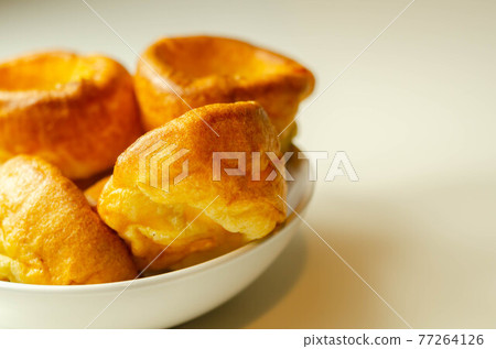 Traditional English Yorkshire pudding, wonderfully crisp and golden baked for a traditional recipe, accompaniment for the perfect Sunday roast Traditional English Yorkshire pudding, wonderfully crisp and golden baked for a traditional recipe, accompaniment for the perfect Sunday roast 77264126