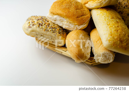 Various types of bread served on a wicker tray, delicious and fresh rolls 77264238