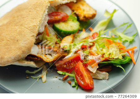 Mediterranean style pitta prepared with spicy chicken, cucumber, tomato, salad and mayo sauce Mediterranean style pitta prepared with spicy chicken, cucumber, tomato, salad and mayo sauce 77264309