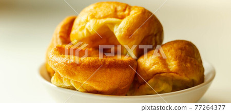 Traditional English Yorkshire pudding, wonderfully crisp and golden baked for a traditional recipe, accompaniment for the perfect Sunday roast Traditional English Yorkshire pudding, wonderfully crisp and golden baked for a traditional recipe, accompaniment for the perfect Sunday roast 77264377