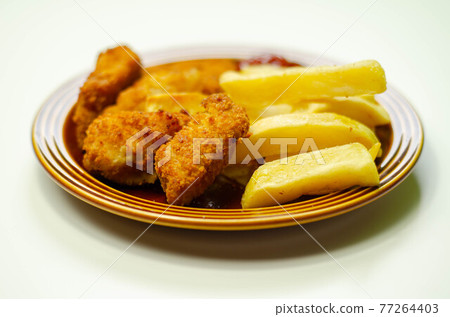 Chicken breast chunks, coated in breadcrumbs with potato chips and ketchup 77264403
