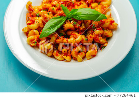 Cooked cellentani pasta with cooked chicken breast and peppers in a spicy tomato and jalapeno dressing Cooked cellentani pasta with cooked chicken breast and peppers in a spicy tomato and jalapeno dressing 77264461