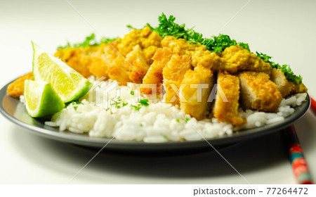 Crispy chicken perked up with an aromatic katsu curry sauce and fragrant fluffy rice 77264472