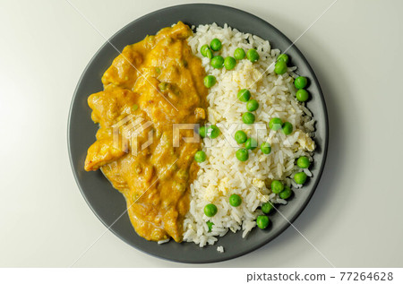 Chicken breast pieces in a mildly spiced coconut curry sauce with fried rice with peas and egg Chicken breast pieces in a mildly spiced coconut curry sauce with fried rice with peas and egg 77264628