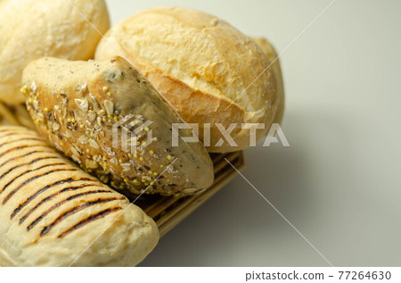 Various types of bread served on a wicker tray, delicious and fresh rolls Various types of bread served on a wicker tray, delicious and fresh rolls 77264630