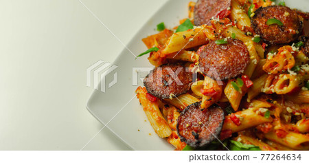 Pennette pasta in a spicy tomato sauce with sliced pepperoni, mozzarella, and mature cheddar cheeses 77264634