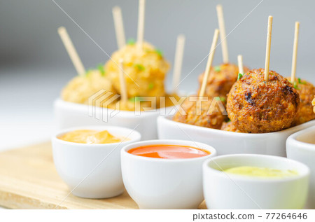Various mini chicken kievs and sweet potato falafels served with sauces 77264646