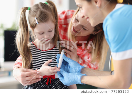 Little girl has doctor taking blood test with lancet Little girl has doctor taking blood test with lancet 77265133