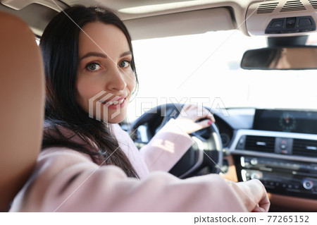Portrait of smiling woman driver in car salon 77265152