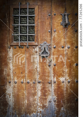 ancient wooden door with a metall lattice. Close up ancient wooden door with a metall lattice. Close up 77265266