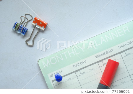 high angle view of weekly planner and notepad on table  77266001