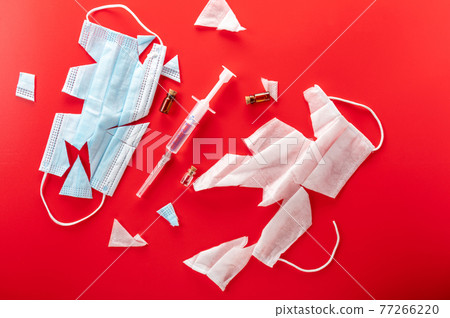 Syringe with medical mask and drugs. Medical syringe on a red background. Syringe with medical mask and drugs. Medical syringe on a red background. 77266220