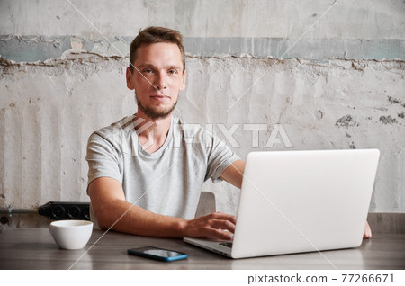 Smiling man working in laptop at home. Smiling man working in laptop at home. 77266671