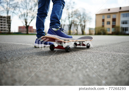 Closeup of skateboarder legs. Kid riding skateboard outdoor. Concept of leisure activity, sport, extreme, hobby. Closeup of skateboarder legs. Kid riding skateboard outdoor. Concept of leisure activity, sport, extreme, hobby. 77268293