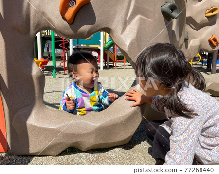 Girls and boys playing with playground equipment in the park Girls and boys playing with playground equipment in the park 77268440