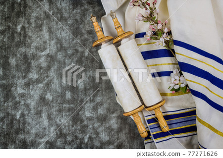 Jewish holidays, during prayer items kippa with prayer shawl tallit on torah scroll 77271626