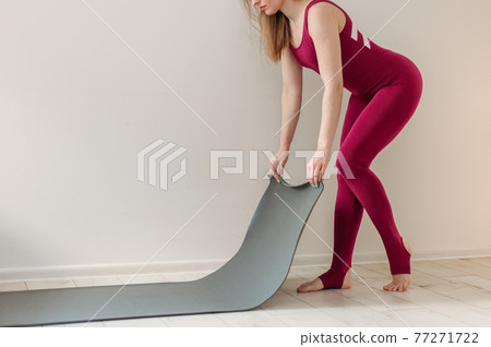 Yoga at home active lifestyle woman rolling exercise mat in living room for meditation yoga. Indoor and outdoor workout. Sport and healthy active lifestyle concept. 77271722