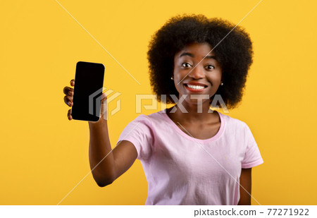 Positive african american woman showing cellphone with space for mobile app design on screen over yellow background Positive african american woman showing cellphone with space for mobile app design on screen over yellow background 77271922