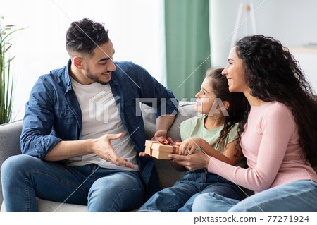 Portrait of cute little daughter and wife making surprise for arab man Portrait of cute little daughter and wife making surprise for arab man 77271924