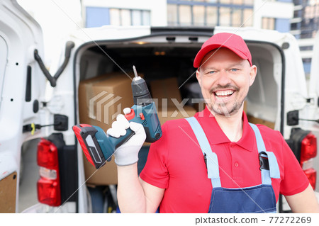 Portrait of smiling man with drill in his hands 77272269