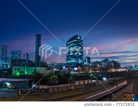 Night panorama with a view of the skyscraper Business Center 101 tower and a high chimney of the Kiev combined heat and power plant against the background of city lights and the sky at sunset 77272652